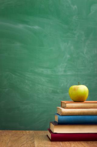 School books with apple on desk