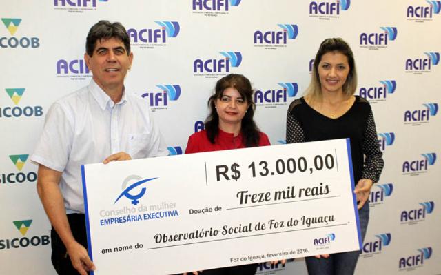 Acompanhada do presidente da ACIFI, João Batista de Oliveira, a conselheira Graci Braga Bergmann fez a entrega do cheque à vice-presidente para Assuntos de Controle Social do OSFI, Mônica Doerner